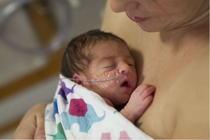 La photo d'un garçon aidant son père à réchauffer les nouveau-nés a fait le tour d'Internet.